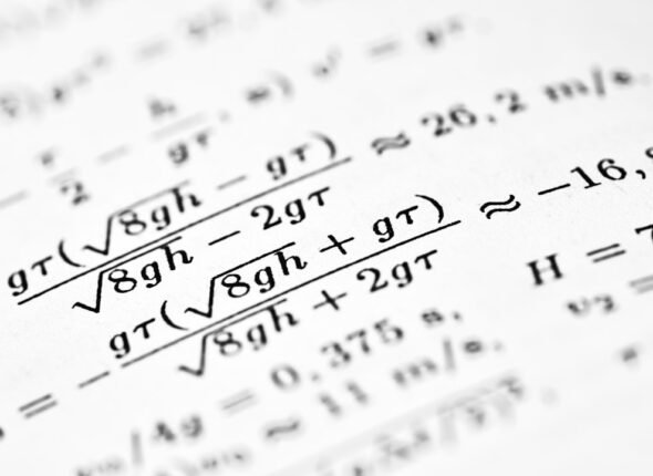 Mathematical formulas are written on a white sheet of paper.