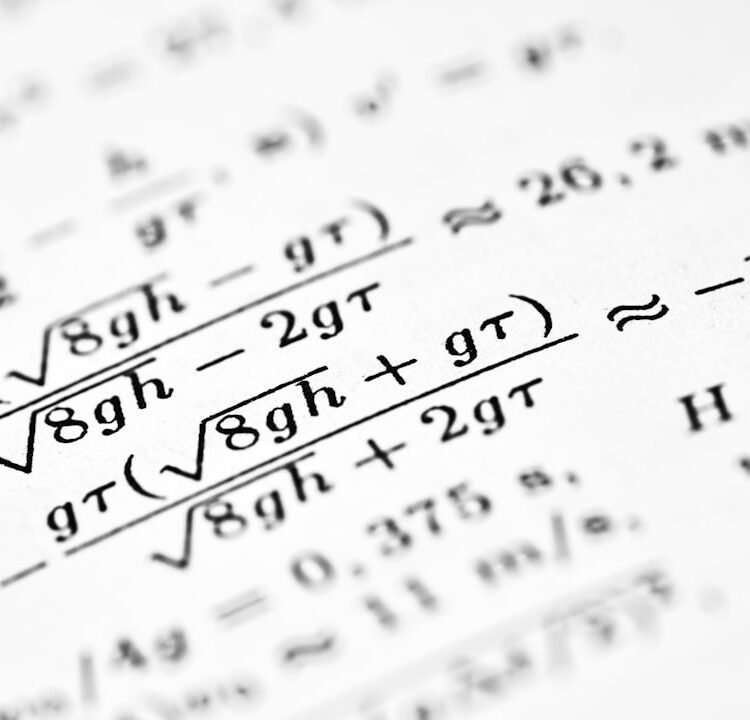 Mathematical formulas are written on a white sheet of paper.