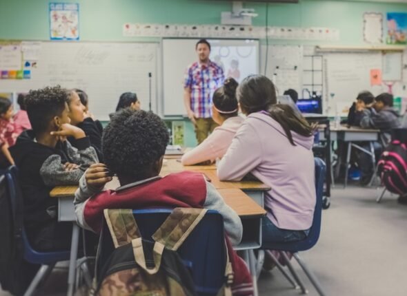 Sala de aula moderna com estudantes utilizando tecnologia digital para aprendizado