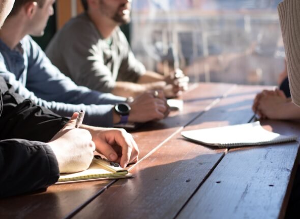 Líder conduzindo reunião de equipe em ambiente corporativo moderno