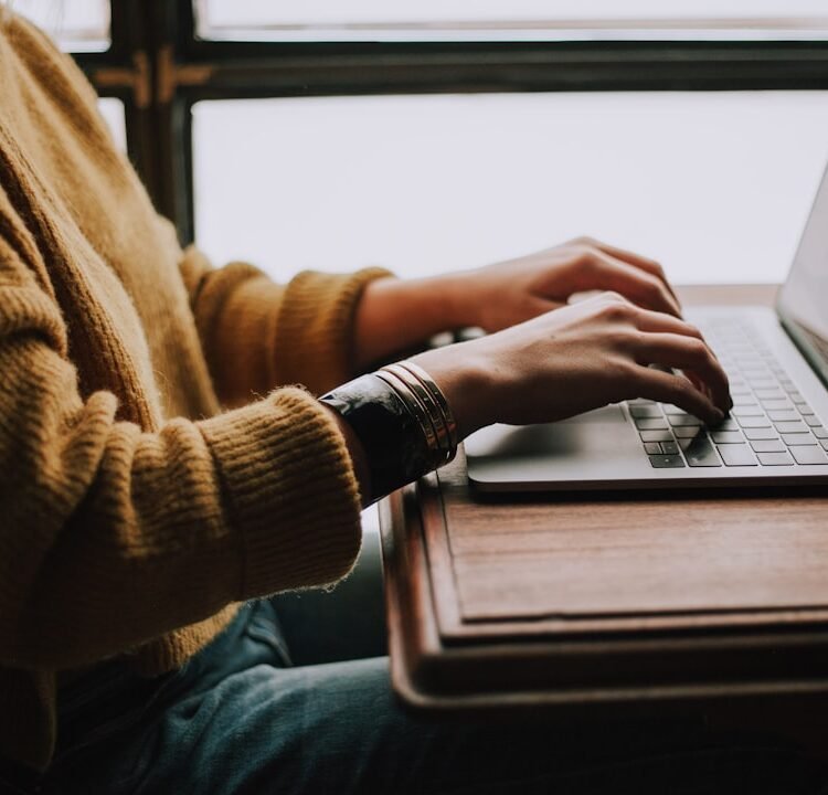 Pessoa estudando de forma autônoma com laptop e materiais de aprendizado digital em ambiente iluminado