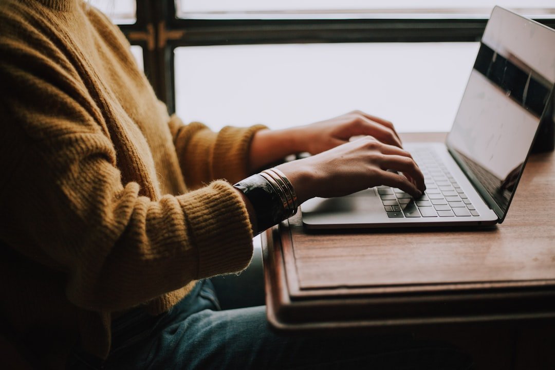 Pessoa estudando de forma autônoma com laptop e materiais de aprendizado digital em ambiente iluminado